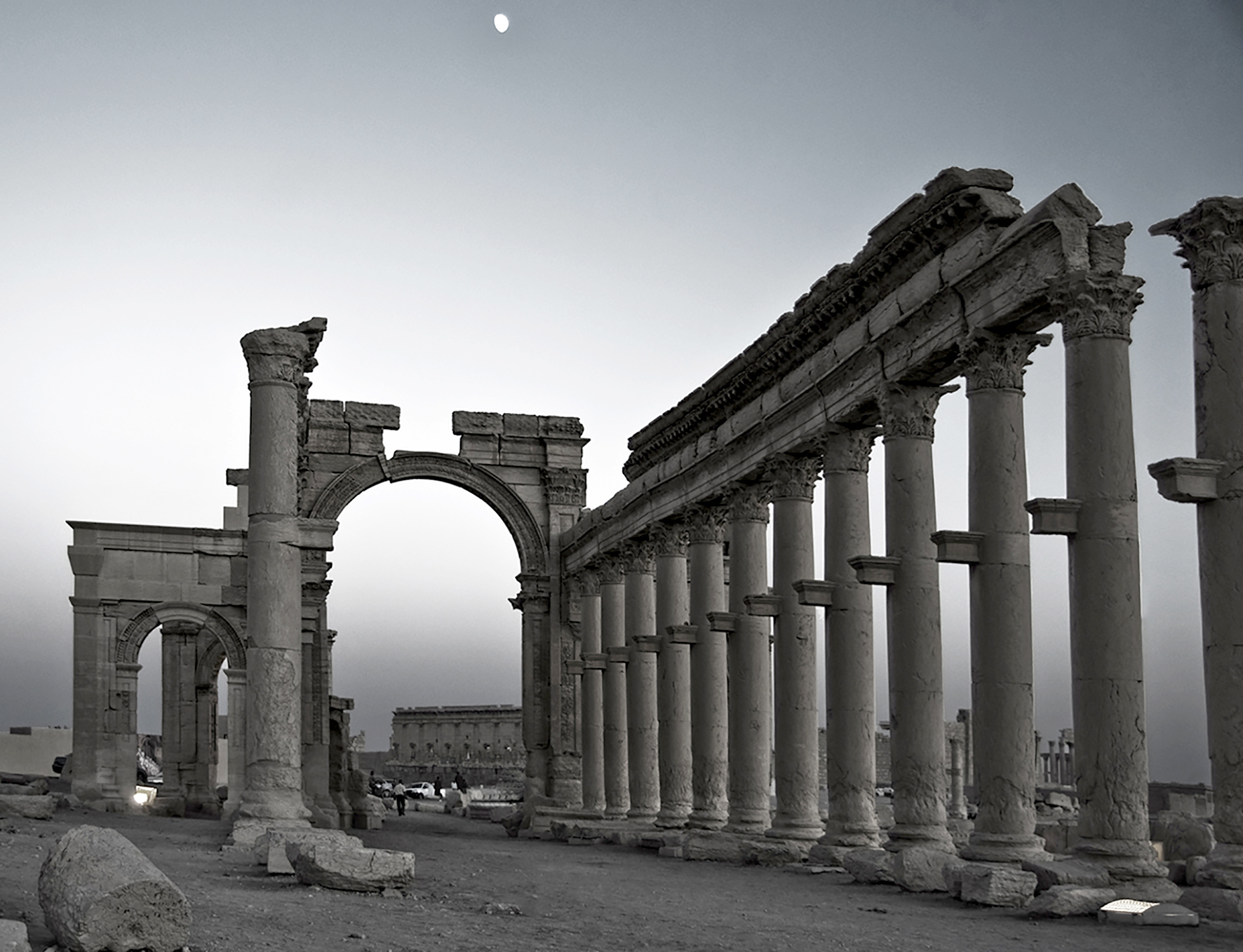 The monumental arch in the eastern section of Palmyra's colonnade. (significantly damaged in 2017) The temple of Bel in the foreground. Syria